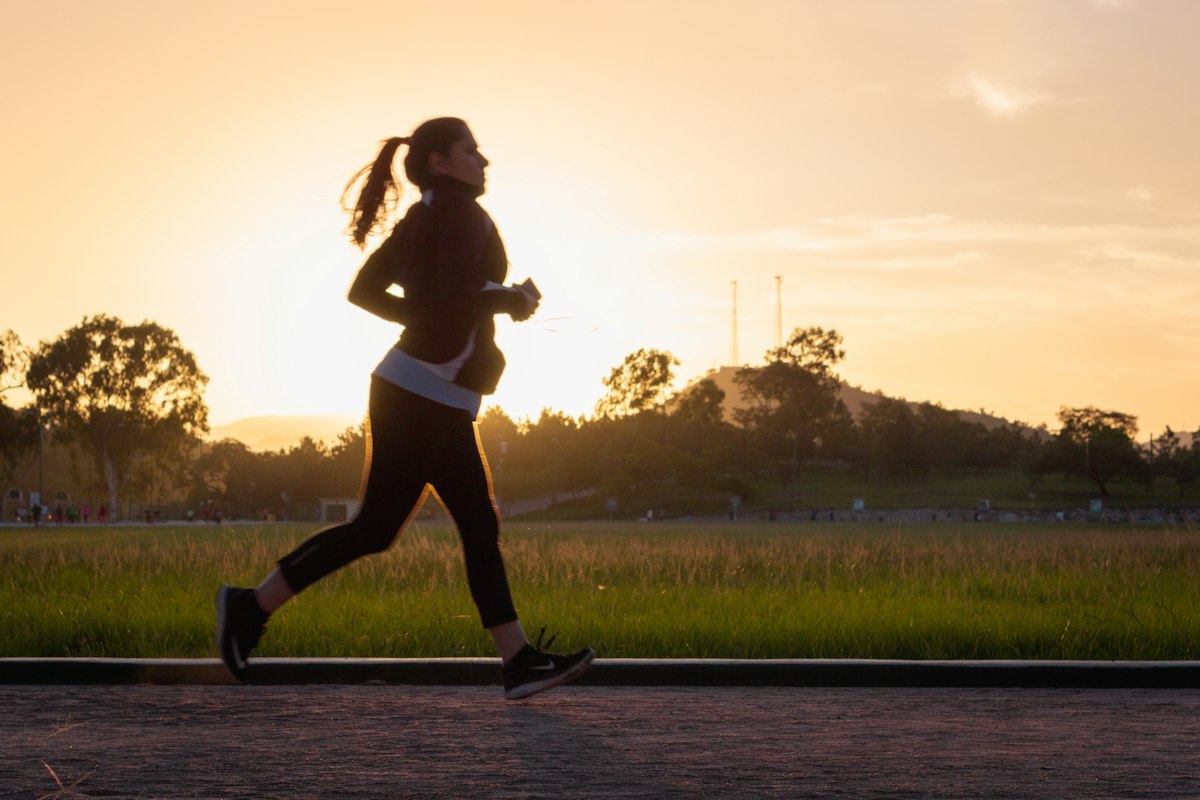 Mujer corriendo al atardecer como ejemplo de intensidad aeróbica al entrenar por pulsaciones
