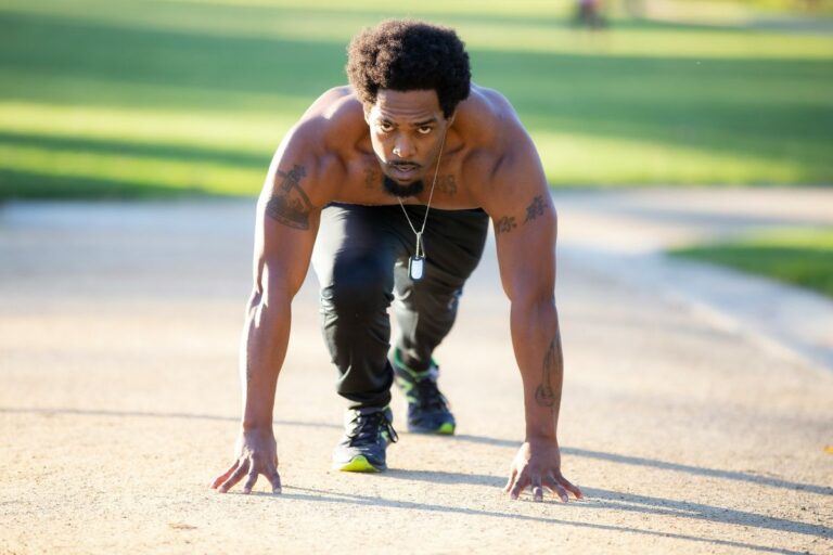 Hombre preparado para hacer flexiones en la calle, entrenamiento con peso corporal sin gimnasio